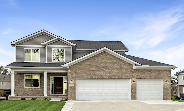 view of front of home with driveway, an attached garage, a front yard, and brick siding