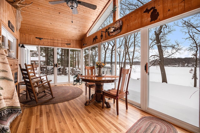 sunroom / solarium with lofted ceiling, wooden ceiling, and ceiling fan