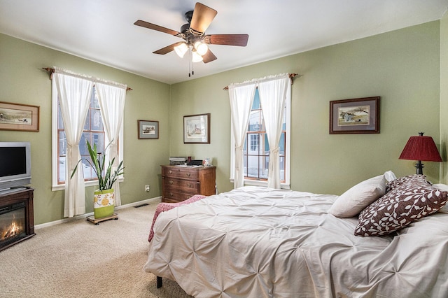 carpeted bedroom with ceiling fan and multiple windows