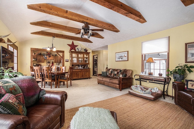 carpeted living room featuring ceiling fan with notable chandelier, lofted ceiling with beams, and a textured ceiling