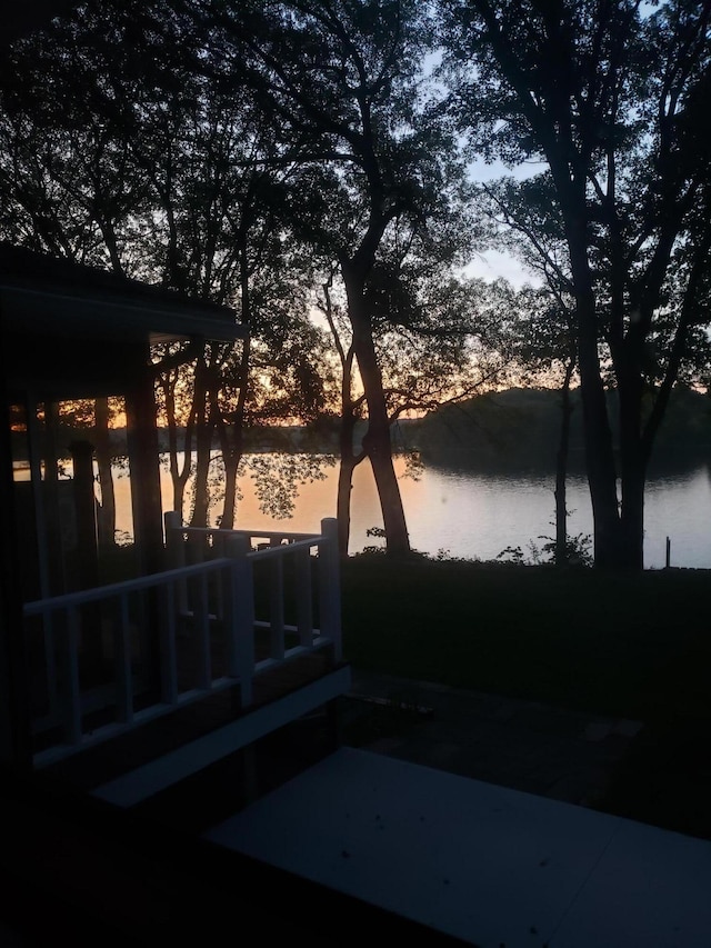 yard at dusk featuring a water view