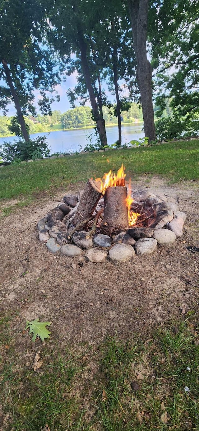 view of yard with a water view and a fire pit
