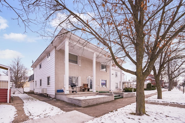 view of snow covered back of property