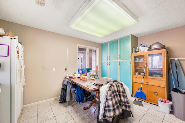 dining area featuring light tile patterned floors and a textured ceiling