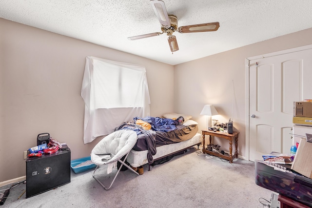 bedroom with ceiling fan, light carpet, and a textured ceiling