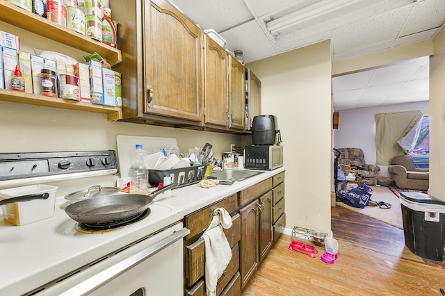 kitchen featuring a paneled ceiling, white electric range, sink, and light hardwood / wood-style flooring