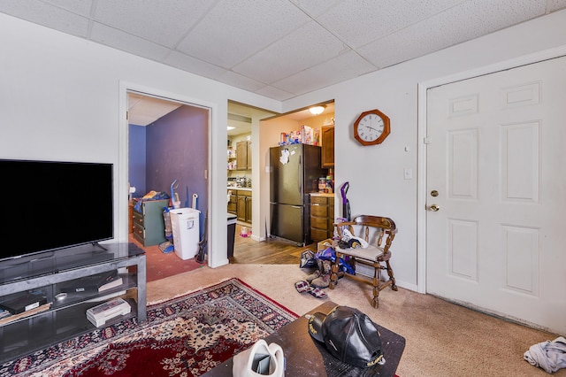 carpeted living room with a paneled ceiling