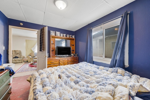 carpeted bedroom with a drop ceiling