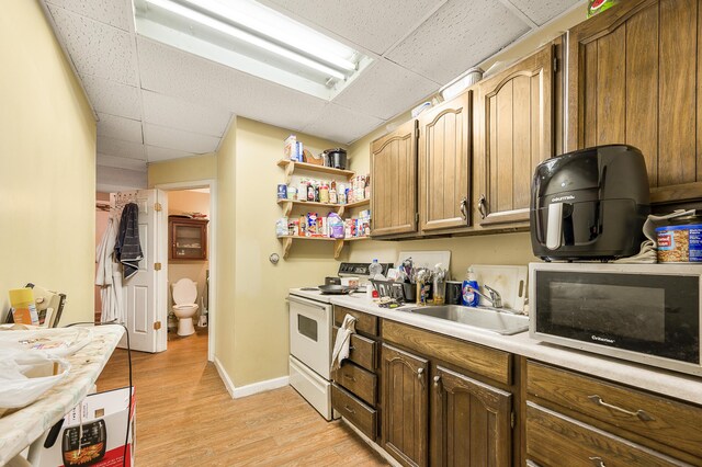 kitchen with sink, a paneled ceiling, electric range, and light hardwood / wood-style flooring