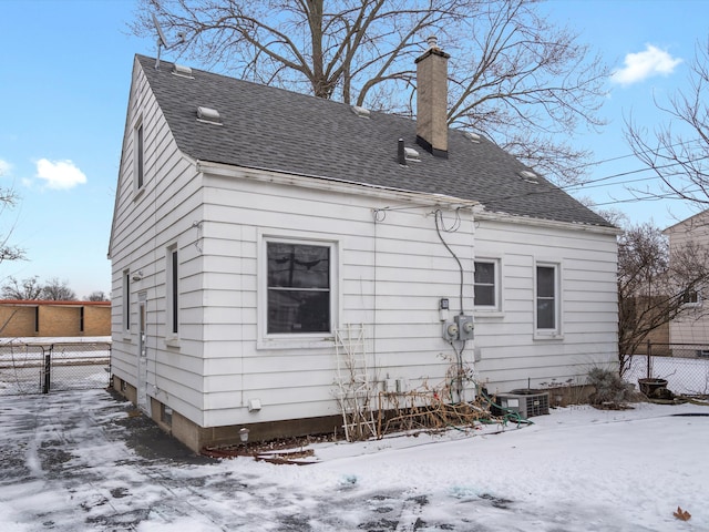 snow covered rear of property with central AC