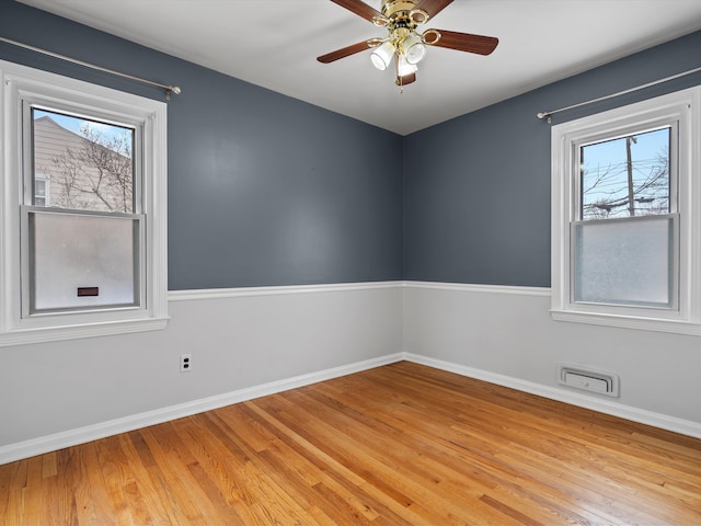 spare room with plenty of natural light, light hardwood / wood-style floors, and ceiling fan