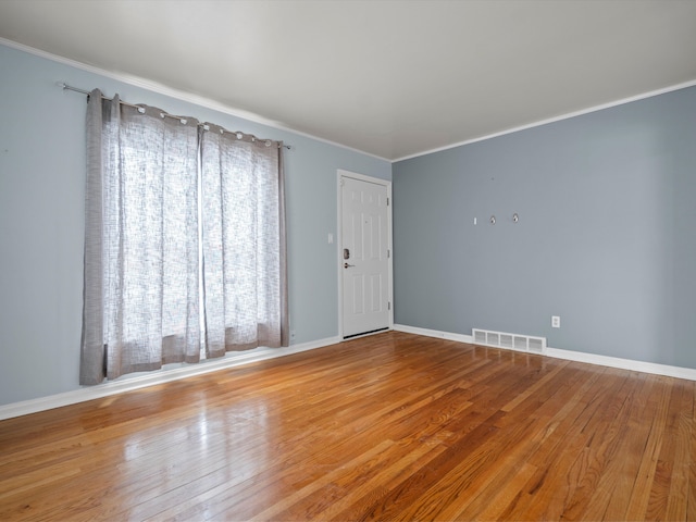 empty room featuring crown molding and light hardwood / wood-style floors