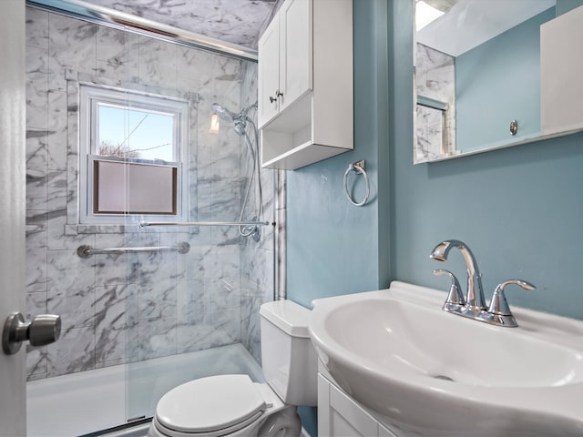 bathroom with a shower with door, sink, and toilet