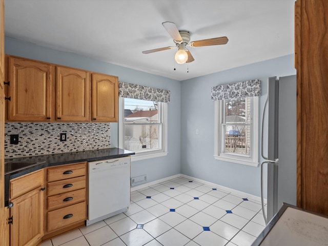 kitchen featuring refrigerator, dishwasher, sink, backsplash, and ceiling fan