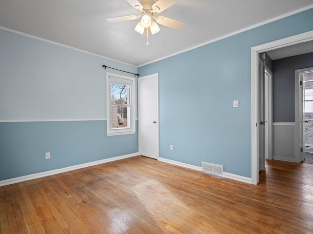 empty room with hardwood / wood-style flooring, ceiling fan, and ornamental molding