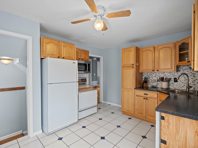 kitchen featuring sink, tasteful backsplash, white fridge, ceiling fan, and stove