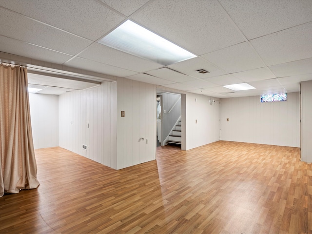 basement with hardwood / wood-style flooring and a paneled ceiling