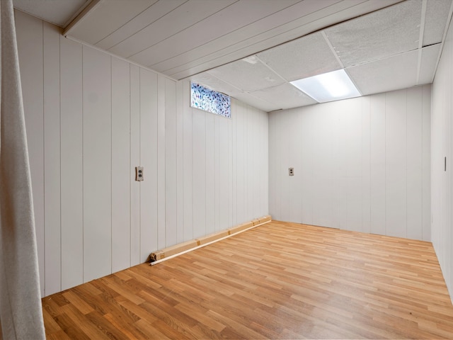 basement featuring hardwood / wood-style floors and a drop ceiling