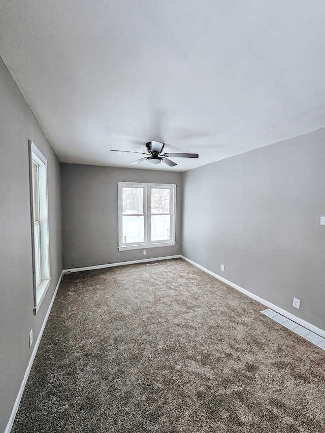 carpeted spare room with ceiling fan