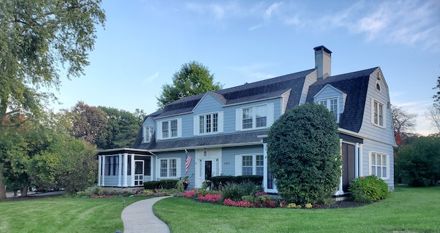 view of front of house featuring a front lawn and a sunroom