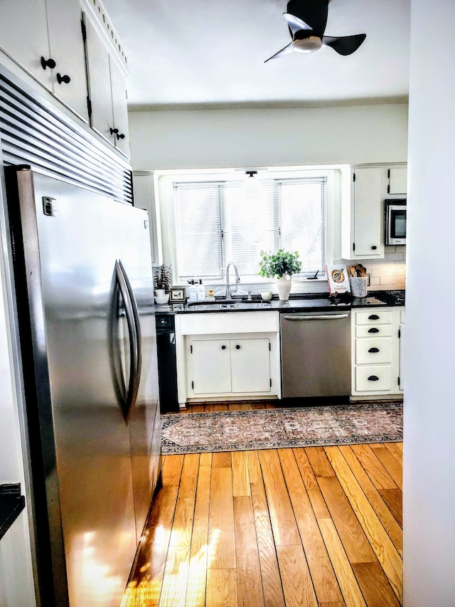 kitchen featuring sink, white cabinetry, light hardwood / wood-style flooring, appliances with stainless steel finishes, and ceiling fan