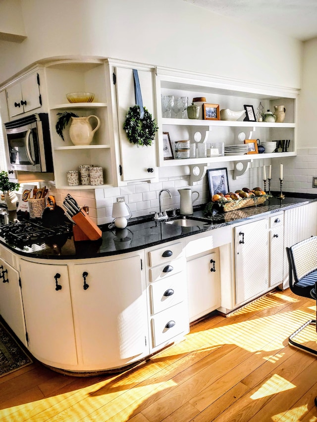 kitchen with sink, white cabinets, and backsplash