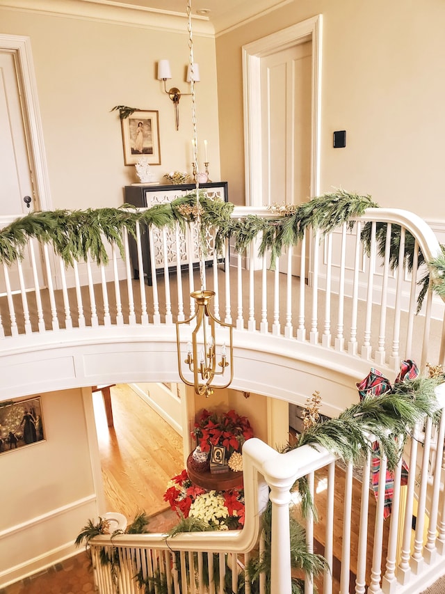 stairway featuring hardwood / wood-style flooring and crown molding