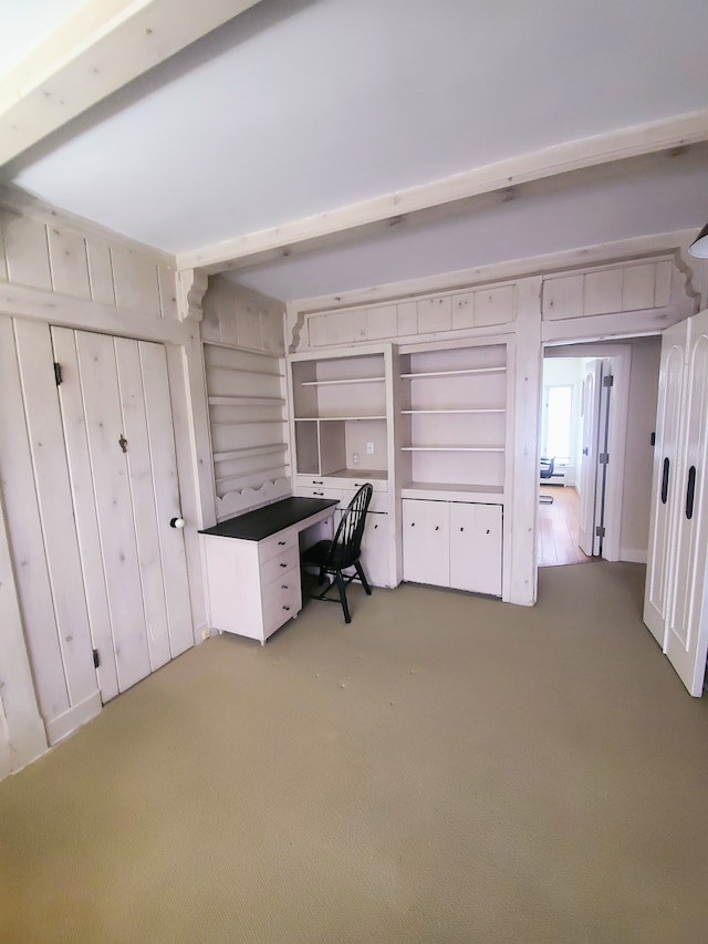 unfurnished office with light colored carpet and beamed ceiling