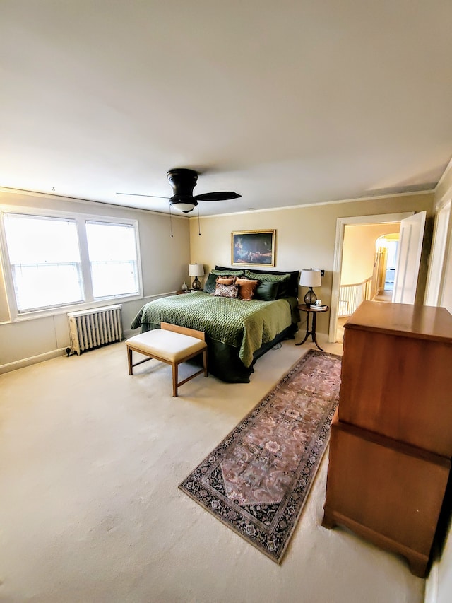 carpeted bedroom featuring ceiling fan and radiator