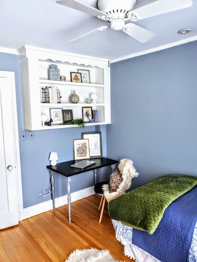 living area with crown molding, hardwood / wood-style floors, ceiling fan, and built in shelves