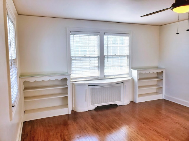 interior space with ceiling fan, dark hardwood / wood-style floors, and radiator