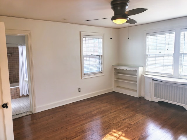 unfurnished room featuring ceiling fan, dark hardwood / wood-style flooring, and radiator