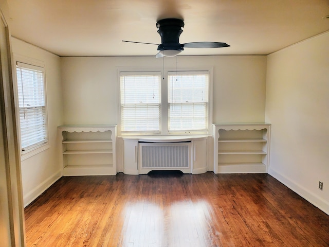 unfurnished room with radiator, dark wood-type flooring, and ceiling fan