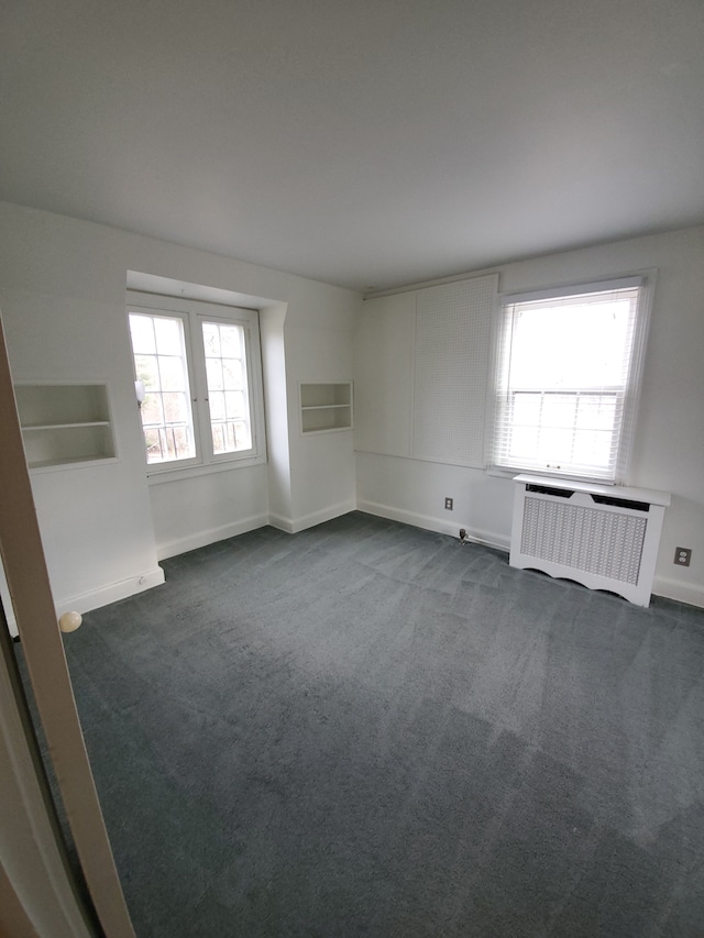 carpeted empty room with radiator