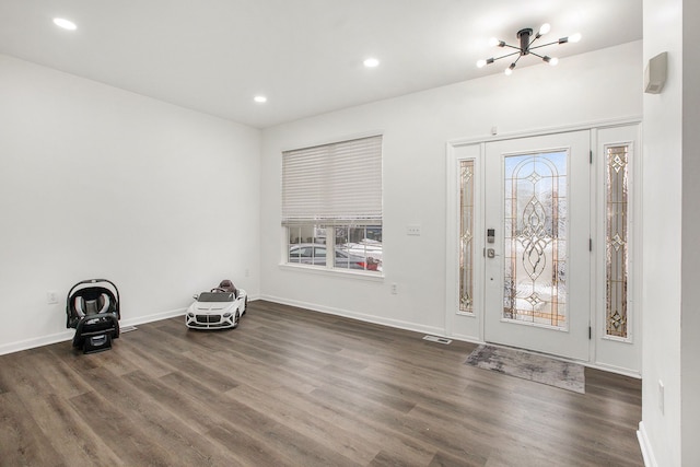 foyer with a chandelier and dark hardwood / wood-style flooring