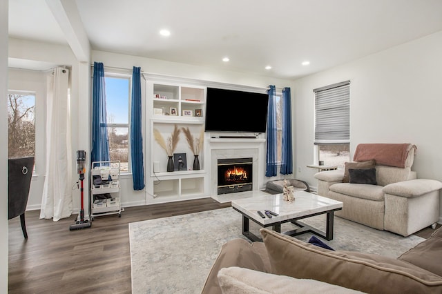 living room with dark hardwood / wood-style flooring and a high end fireplace