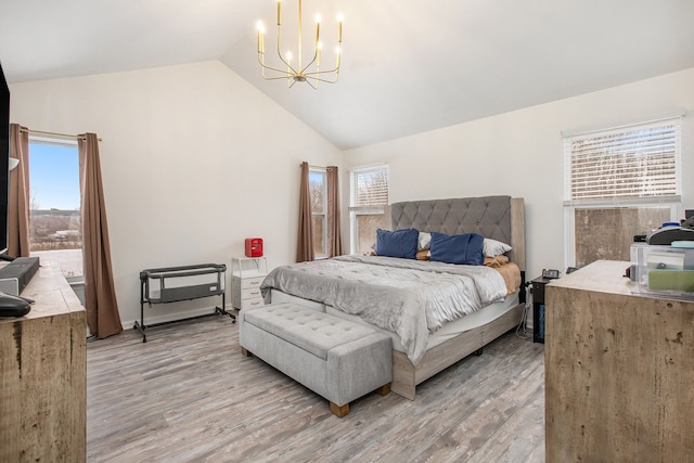 bedroom featuring lofted ceiling, a chandelier, light hardwood / wood-style floors, and multiple windows