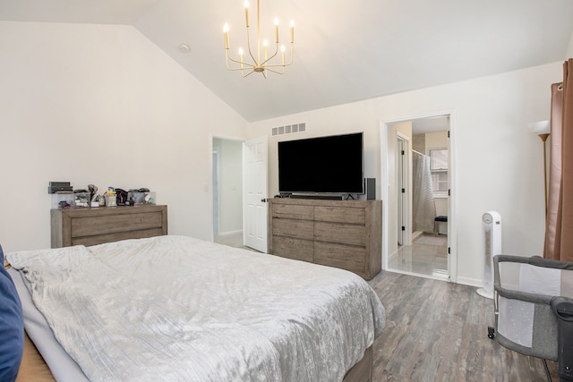 bedroom featuring hardwood / wood-style floors, ensuite bath, vaulted ceiling, and a notable chandelier