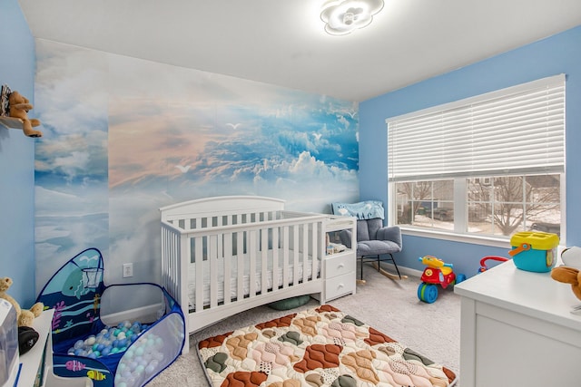 bedroom with a nursery area and carpet floors