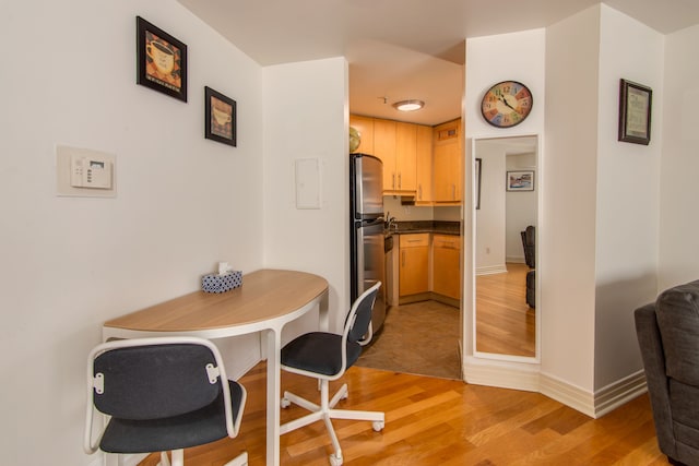 dining room featuring light wood-style flooring and baseboards