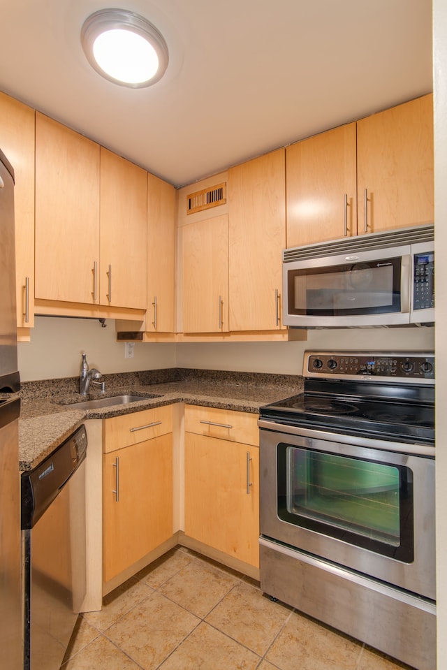 kitchen featuring visible vents, stainless steel appliances, light brown cabinets, a sink, and light tile patterned flooring