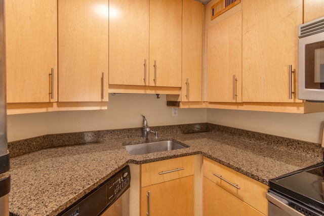 kitchen with dishwasher, electric range oven, a sink, and light brown cabinetry