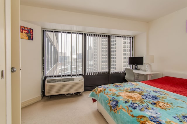 bedroom with carpet floors, an AC wall unit, and baseboards