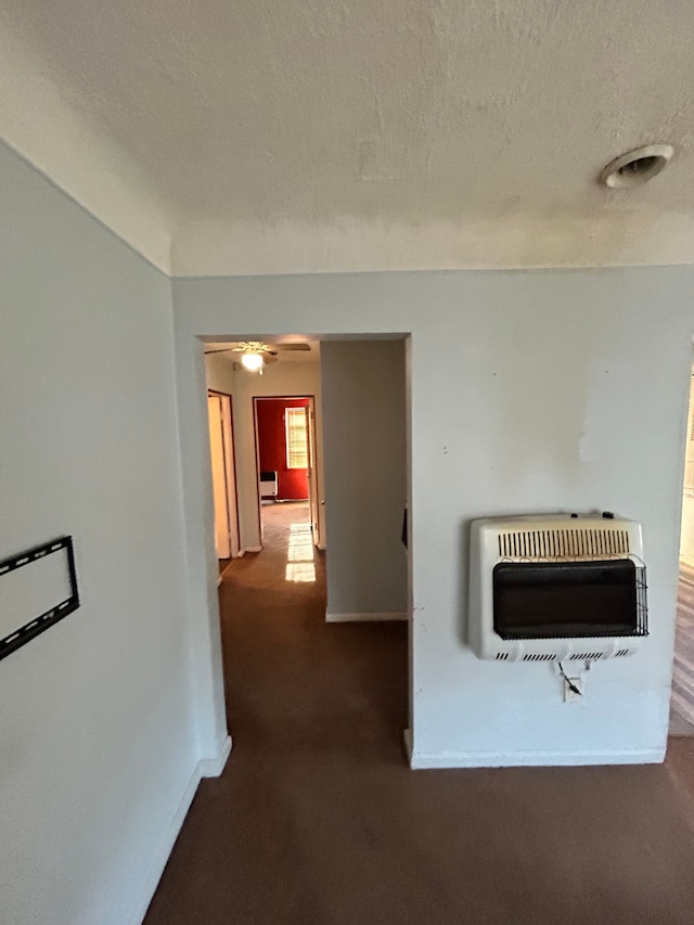 hallway with heating unit and a textured ceiling