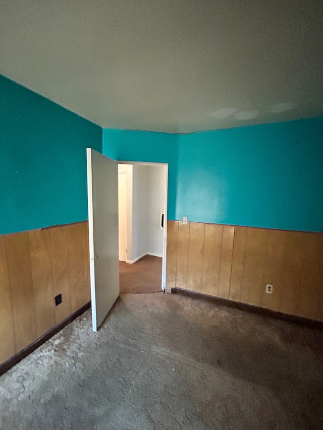 unfurnished room featuring wood walls