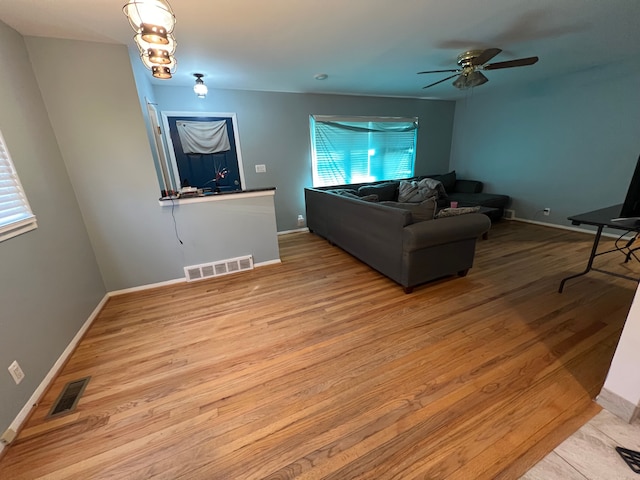 living room with ceiling fan and light hardwood / wood-style flooring