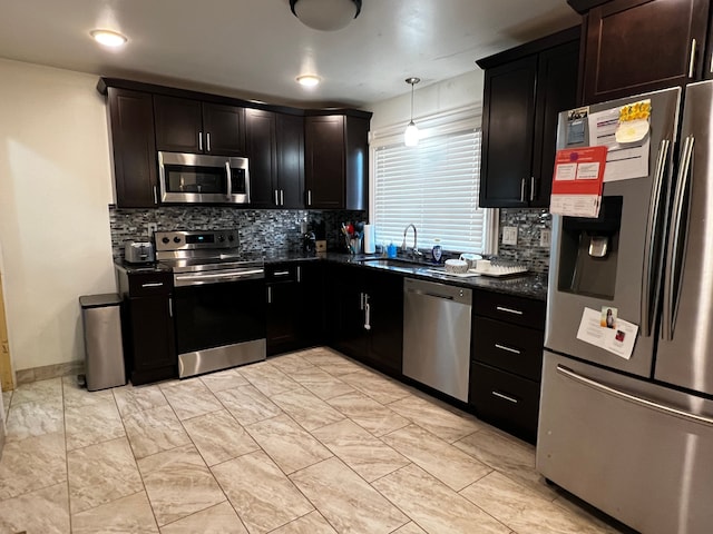 kitchen featuring decorative backsplash, appliances with stainless steel finishes, sink, and hanging light fixtures