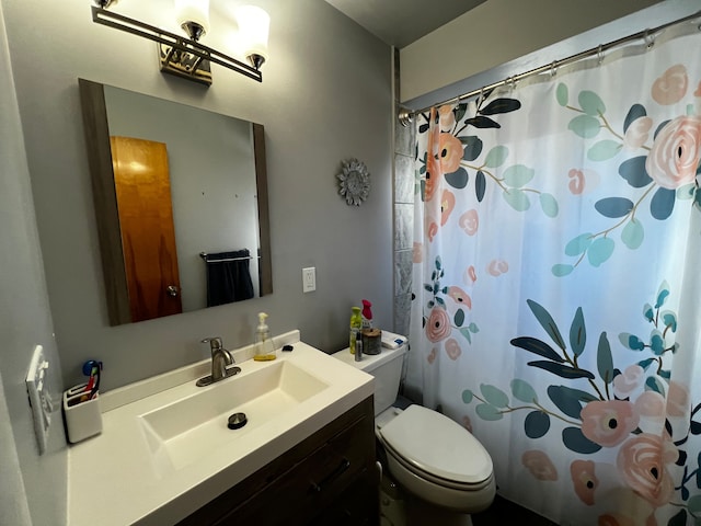 bathroom featuring vanity, curtained shower, and toilet