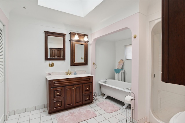 bathroom featuring tile patterned flooring, vanity, and a tub to relax in