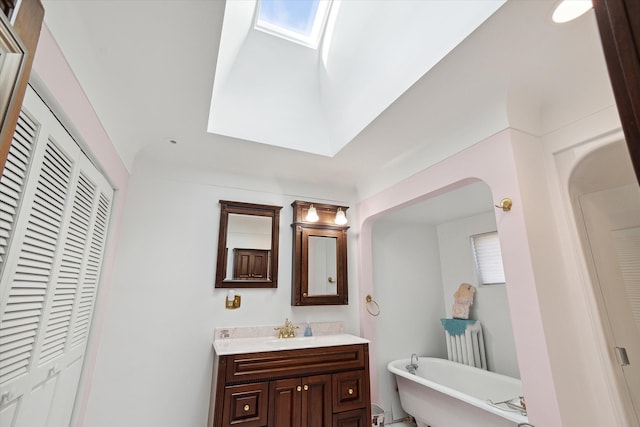 bathroom with vanity, a washtub, and a skylight